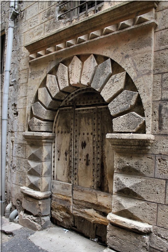 Porte cloutée du XVème, encadrement à bossages, onze claveaux en mitre et une frise avec 10 pointes de diamant